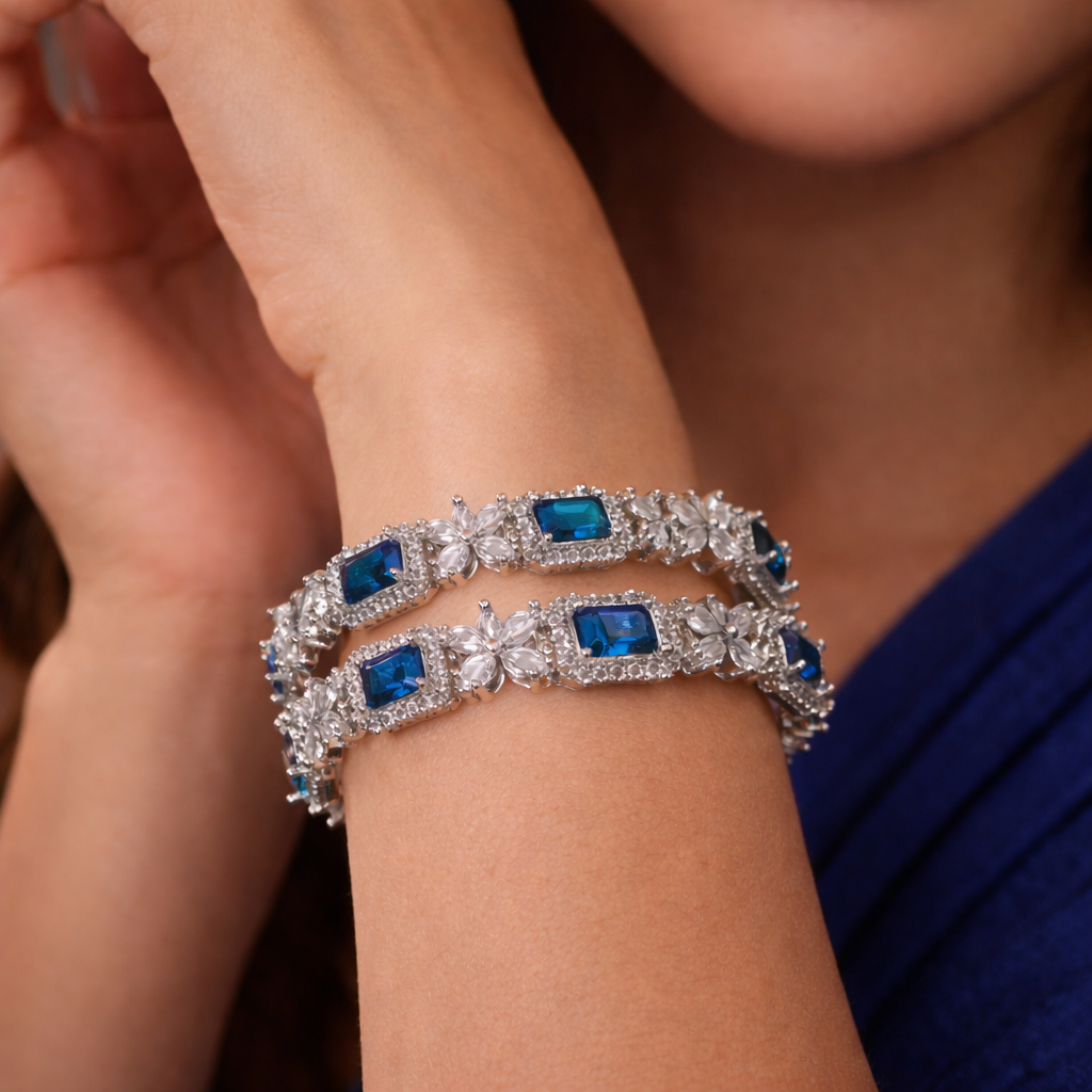 Silver bracelet with blue gemstones on a person's wrist against a blurred background