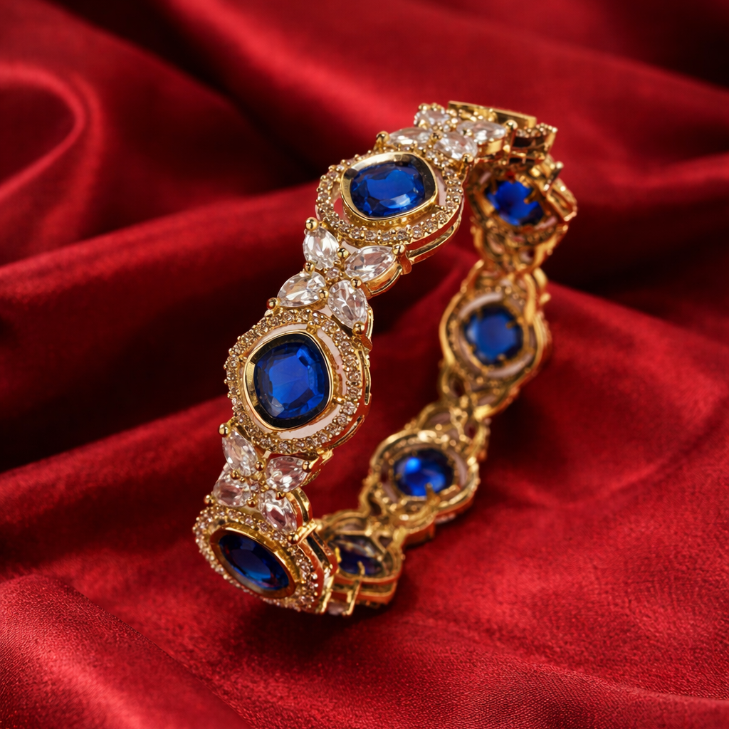 Gold bracelet with blue stones on a red fabric background