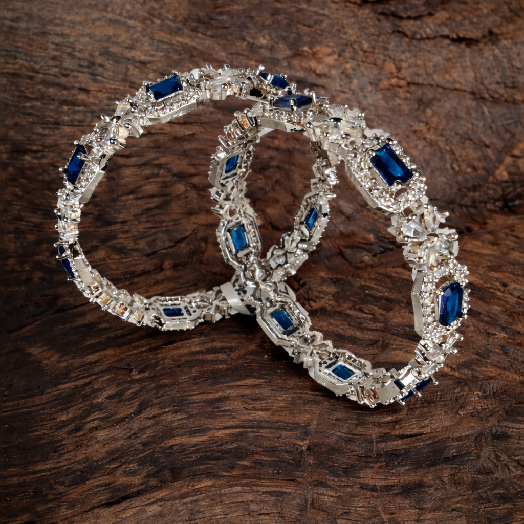 Pair of silver bracelets with blue stones on a wooden surface