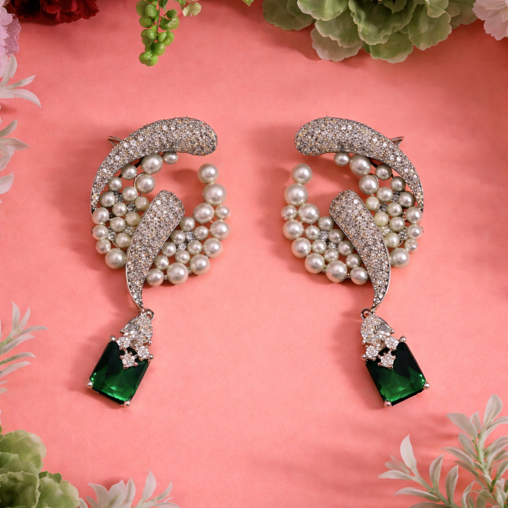 rhodium-plated earrings studded with cubic zirconia, pearls, and a large green stone